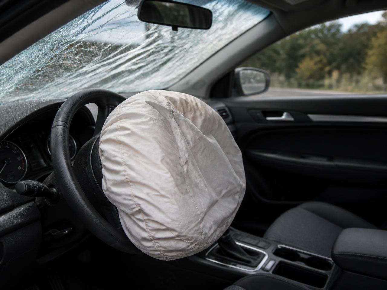 Deployed driver airbag and cracked windshield inside a car
